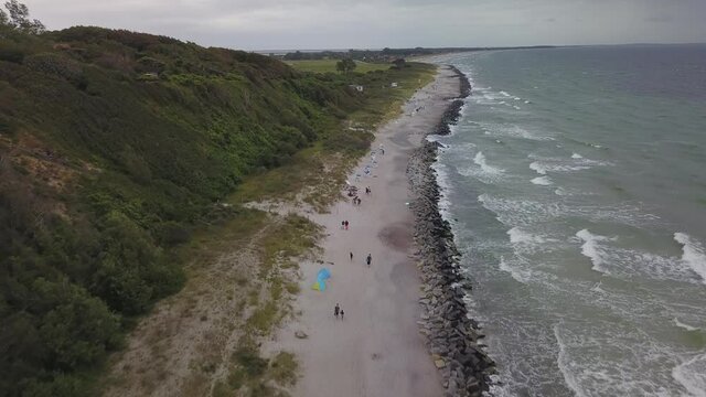 Drone flight along a coast on a cloudy day and strong waves in Germay.