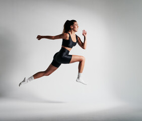 Fototapeta na wymiar fitness girl dressed in black, doing a big jump