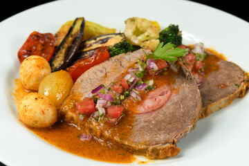   a dish with meat stuffed with smoked sausage served with grilled vegetables