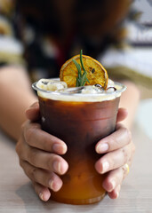 Close-up view, Ice mixed fruit juice in a woman hand, Orange flavored fruit juice drink.