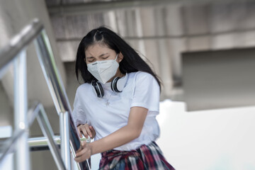 Tired Asian teenage have severe headache symptoms and exhaustion in Public Places, Signs Symptoms of Coronavirus spread, Covid19