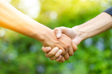 A male close up holding a hand between two colleagues who have a good relationship concept in a...