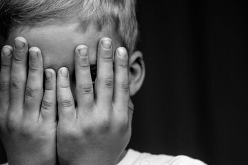 domestic violence against children. . the child covered his eyes with his hands. the child is scared