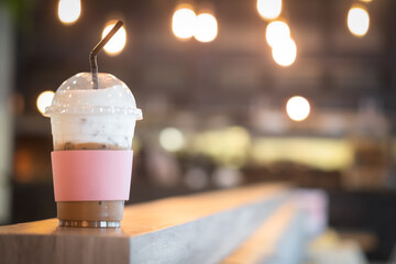 Iced cappuccino and milk foam with pink paper sleeve