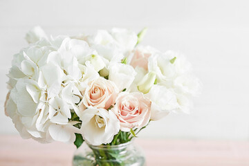 Bouquet of roses, eustomas and hydrangeas on table. Cup of tea and photo frame. Greeting card for mothers day. Cozy good morning. Happy Birthday. Wedding invitation. Flowers composition for Valentine