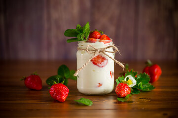 sweet homemade yogurt with ripe fresh strawberries in a jar