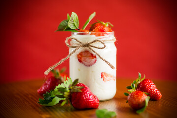 sweet homemade yogurt with ripe fresh strawberries in a jar
