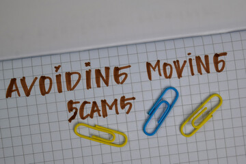 Avoiding Moving Scams write on a book isolated wooden table.