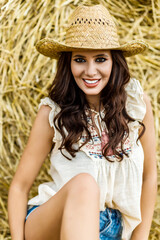 Beautiful cowboy woman Posing near at the haystacks, Fashion concept.