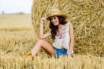 Beautiful cowboy woman Posing near at the haystacks, Fashion concept.