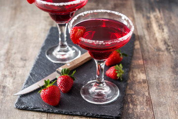 Strawberry red cocktail in glass on wooden table
