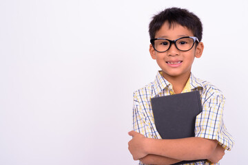 Portrait of cute Asian boy wearing eyeglasses as student with book