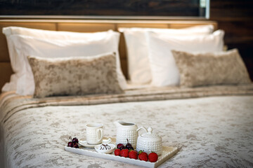 The breakfast tray is on the bed with berry