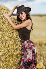 Beautiful cowboy woman Posing near at the haystacks, Fashion concept.