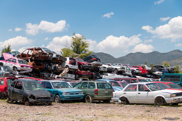 Fototapeta na wymiar Mexico City / Mexico. June 19 2020: Old Cars Piled up in a Metal Recycling Yard Waiting to be Dismantled and Crushed.