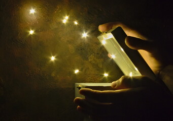 Hands opening a box and letting out star-shaped lights.