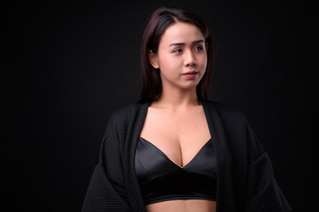 Fototapeta premium Young beautiful Asian transgender woman against black background