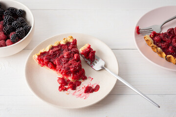 Cherry clafoutis on white background, plates with a portion of the pie and spoons