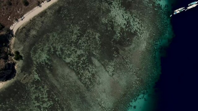 Aerial 4k view from a reef and a dock with boats in a paradise island in Kanawa Komodo - Indonesia