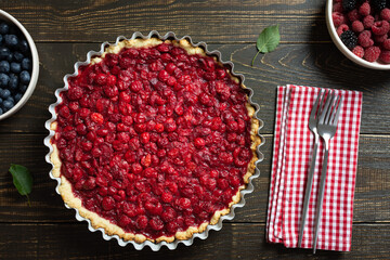 Open pie from shortcrust pastry with cherries, cherry clafoutis on wooden background