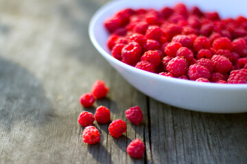 Red fresh raspberries in a white misk on a wooden background with copy space.
Healthy snack. Summer healthy food concept. Healthy organic sweet fruits.