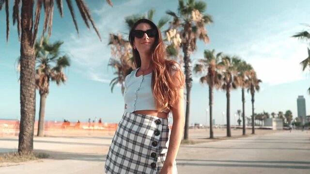 Beautiful young fashionable woman in sexy clothes posing in the green palm tree park. Summer concept photo