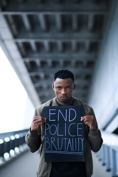 Man with sign standing outdoors, black lives matter concept.