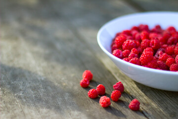Red fresh raspberries in a white misk on a wooden background with copy space.
Healthy snack. Summer healthy food concept. Healthy organic sweet fruits.