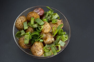 fried zucchini potatoes in uniform and sauerkraut on a black background. Set table in a rustic style.