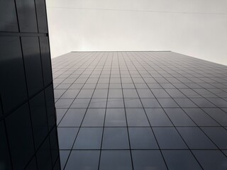 Modern mirror wall decoration of business center, copy space. Bottom view to texture of exterior design. Contemporary pattern of buildings. Looking up.