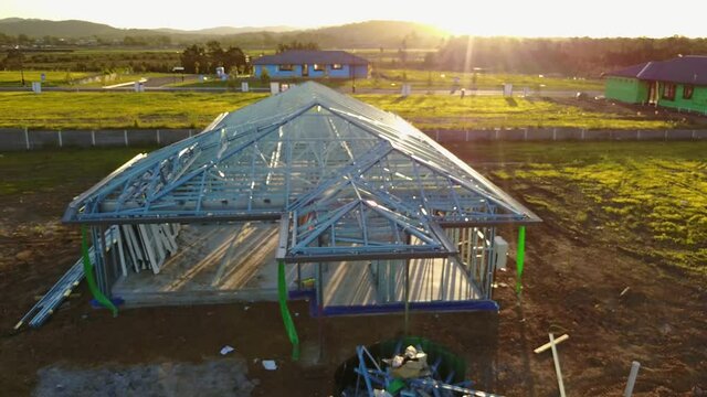 Drone Panning Up New House Being Built Steel Frame Inspiring Sunrise Flares