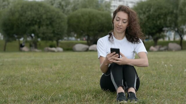 Woman reading on smart phone in city park hd stock footage