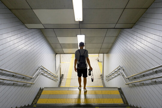 Asian photographer in the road route, ladder in the subway station