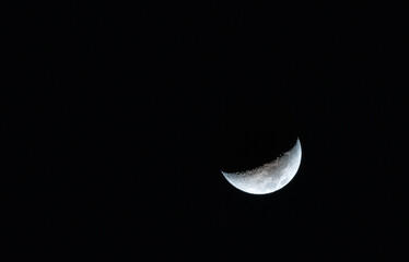 Crescent or waning moon in the dark sky