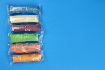 modeling clay set of different colors on a blue background, copy space for text