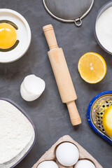 Top view raw ingredients for cooking lemon pie on dark background with copy space. Bakery background.