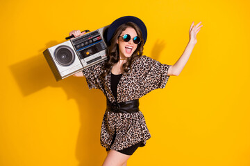 Photo of positive cheerful excited energetic girl hold retro cassette record boom box enjoy rejoice party wear sunglass isolated over bright shine color background