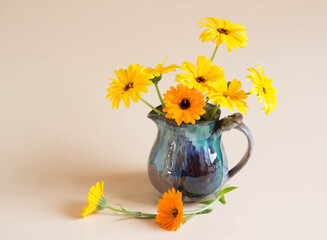 Marigold flowers in vintage vase. Bouquet yellow and orange flowers on pastel background.