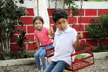 6-year-old boy and girl with protective face masks for virus covid-19, in the park, new normal