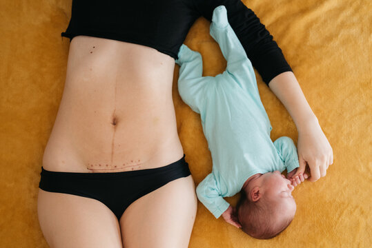 Crop mother and baby lying on bed