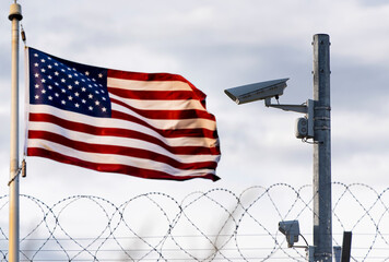USA border, surveillance camera, barbed wire and USA flag, concept picture