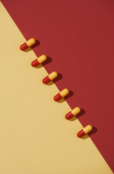 Yellow and red pills isolated on bicolor