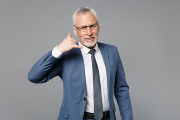 Confident elderly gray-haired mustache bearded business man in blue suit shirt tie isolated on grey background. Achievement career wealth business concept. Doing phone gesture like says call me back.