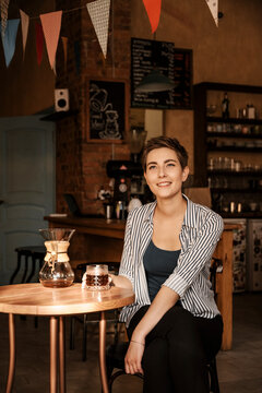 Beautiful smiling brunette girl drinking v60 coffee.