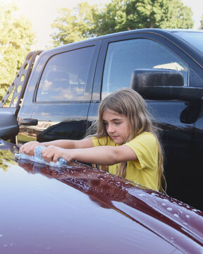 Child Washing Car with Wet Sponge