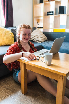 Woman with Red Hair Sitting on the floor with Laptop Computer