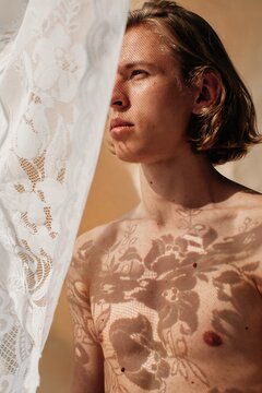 Blond handsome man with floral shadow on his skin