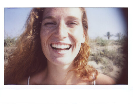 Laughing red-haired gil in sunlight.