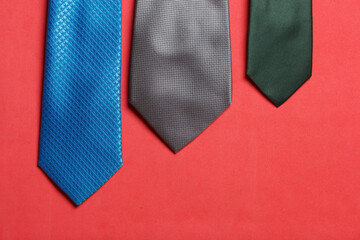 Two men's ties in different colors and sizes. For father and son. Love and Togetherness Objects. On a coral background.