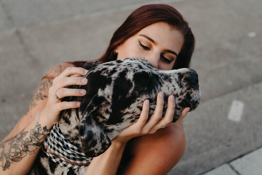 A woman in her twenties training and spending the day with her great dane puppy